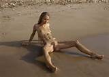 Young skinny babe with hairy pussy walks naked on the beach. 37 photos