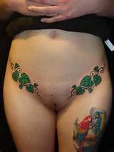 Female with erotic tattoos around her shaved pussy.